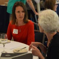 Two alumnae talking at a table